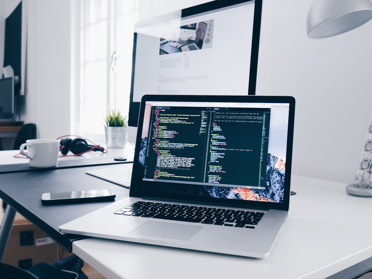 Laptop displaying code in a bright workspace.
